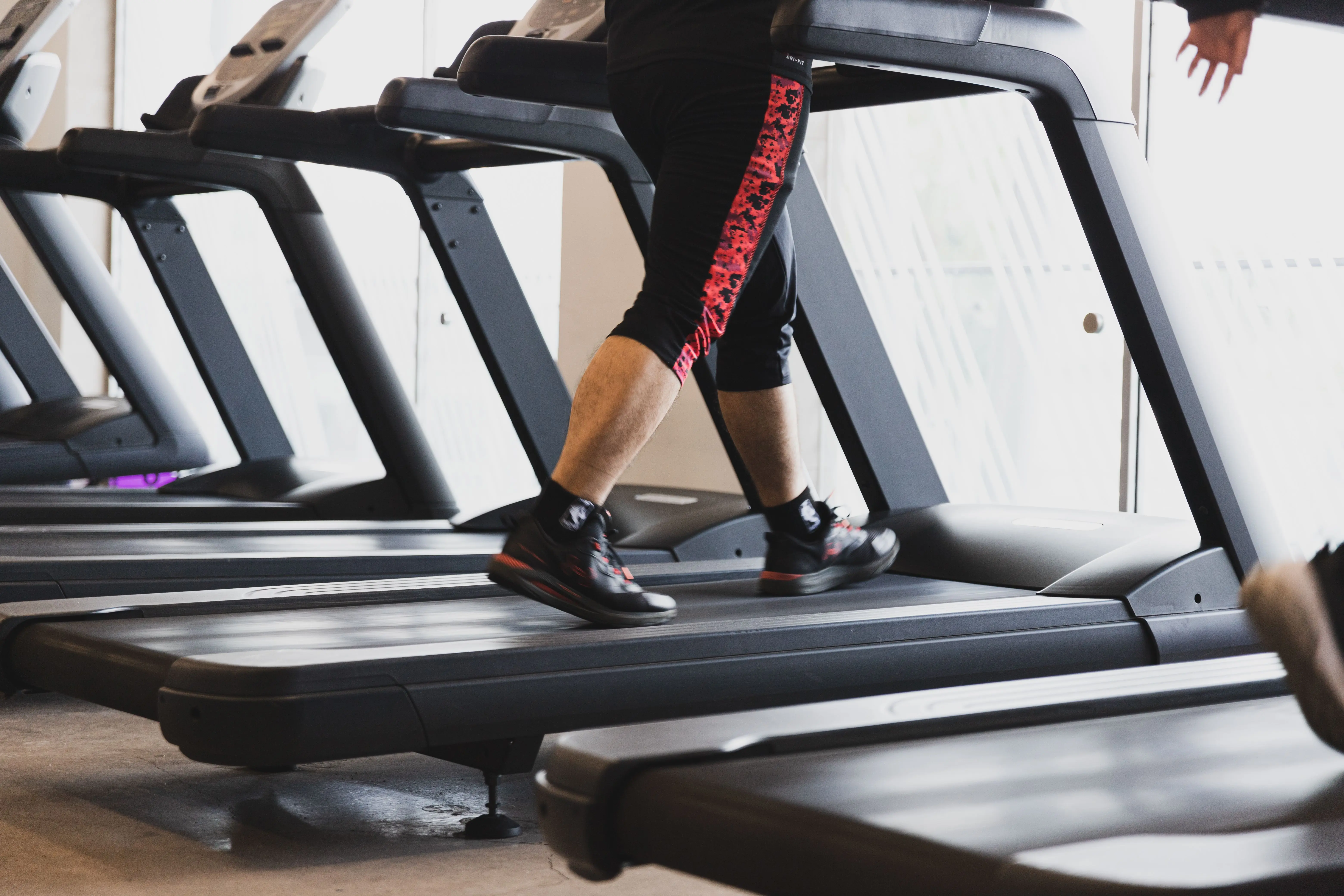 A runner mid-stride on a treadmill deck