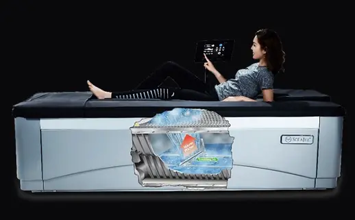 A person lying fully clothed on a Therajet dry hydrotherapy bed